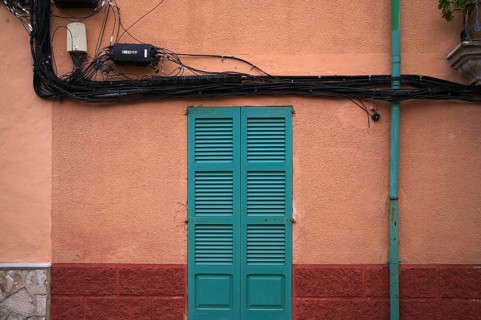 Power lines run outside the house wall, ochre-coloured, Alaró, Calvià, Majorca, Balearic Islands,