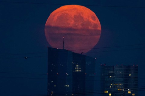 The full moon rises over the European Central Bank (ECB) in Frankfurt am Main, Frankfurt, Hesse,