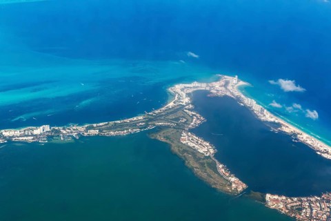 Aerial view through plane window of Caribbean coastline buildings in the hotel zone, Cancun,