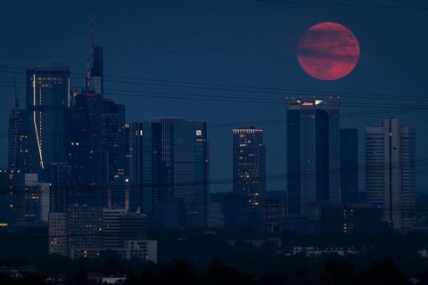 The red full moon passes over Frankfurt's banking skyline. Because of its reddish colour when it