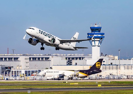 Cologne Bonn Airport with tower. Aircraft taking off. Aircraft registration number ES-MBA, Marabou