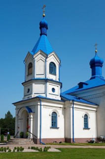 White orthodox church with a striking blue roof, surrounded by nature under a bright sky, Orthodox