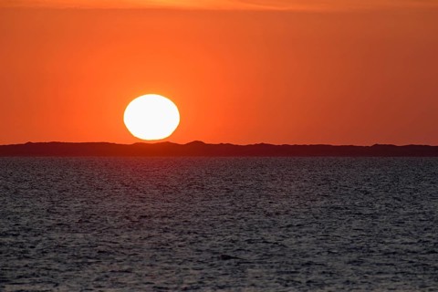 Sunset over the North Sea, on the horizon the contours of the island of Juist, Norddeich, Lower