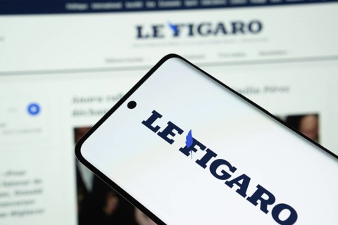 The logo of the newspaper le figaro is displayed on a smartphone screen, and the website le figaro