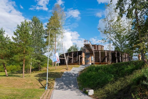 Round wooden building surrounded by trees, in sunny weather and clear sky, brine, graduation tower,
