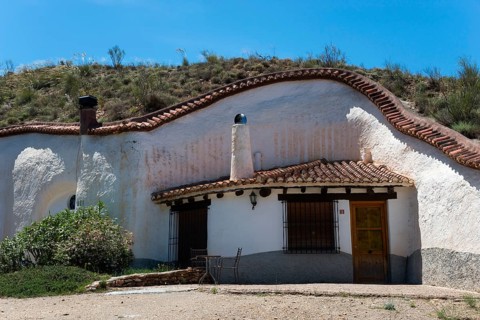 White house with charming rustic style in a hill with clear blue sky in summer, Cuevas del Zenete,