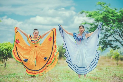 Portrait of smiling girls in national folk costume in a field. Women wearing traditional Nicaraguan