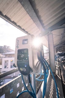 Electric charging station illuminated by sunlight, with blue cables, Kaufland Calw multi-storey car