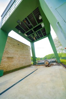 Industrial structure with green construction and machinery on an outdoor concrete floor, Glems
