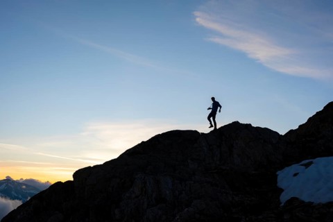 Silhouette of a photographer in front of a blue sky, mountain landscape at sunset, Chamonix,