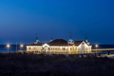Restaurant on Ahlbeck Pier, Seebrücke Ahlbeck illuminated at dusk in the Baltic Sea on Usedom