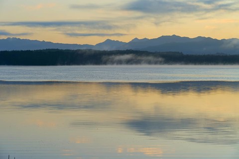 Calm waters with a mountain backdrop under a pastel-coloured sky, Lake Mahinapua, Ruatapu, South