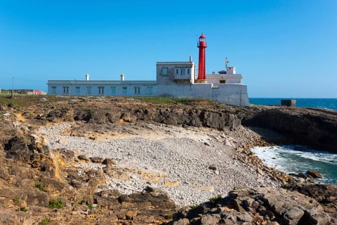 Lighthouse on rocky coast with clear sky and sea view, Farol do Cabo Raso, São Brás de Sanxete