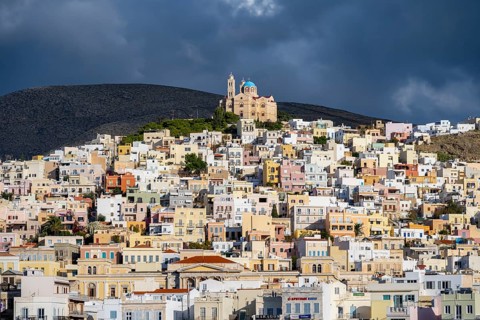 View of the town of Ermoupoli with pastel-coloured houses, on the hill Anastasi Church or Church of