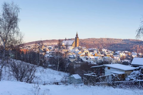 Winter town view with St Wolfgang's Church and Gleesberg in the evening light, Schneeberg in the