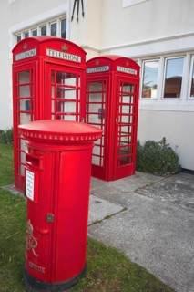 Red telephone boxes and letterbox in front of a British-style building on the Falkland Islands,