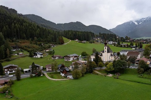 Drone shot, view of village with parish church, Waidring, Pillerseetal, Tyrol, Austria