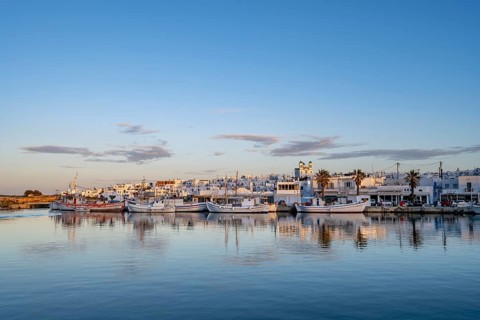 View of Naoussa, Fishing boats in the harbour at sunset, reflected in the sea, White Cycladic