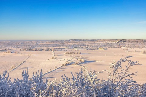Beautiful countryside winter landscape view a cold sunny day with hoarfrost on the treetops and a