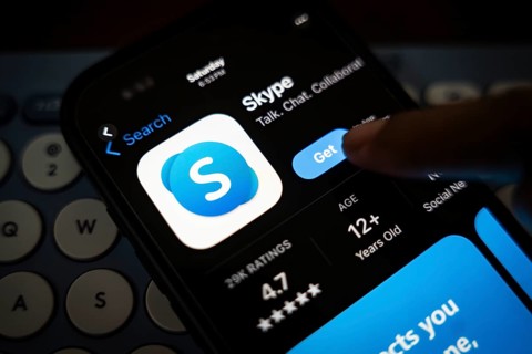 In this photo illustration, a person holds a mobile phone displaying Skype application, in