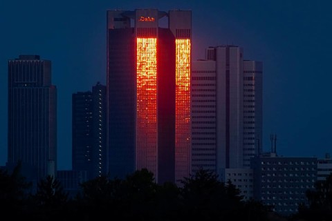 The glass façade of the 186 metre high Trianon Tower in Frankfurt am Main reflects the light of the