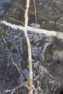 White inclusions in a stone in the shape of a cross, Tamina Gorge between Bad Pfäfers and Bad