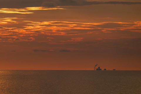 Factory on the horizon, sea surface, evening mood, Baltic Sea