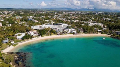 Bird's eye view of aerial view of lagoon and public sandy beach, with the village of Péreybère,