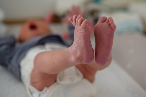 Baby feet high in the air on a soft surface