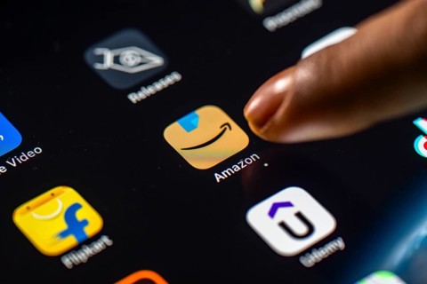 In this photo Illustration a person taps Amazon shopping app icon on a tablet device on 24 May 2025