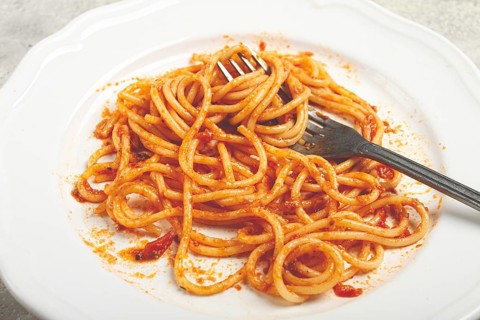 A plate with leftover spaghetti bolognese, no people