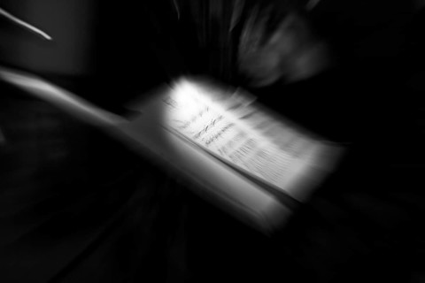 Illuminated sheet of music, music stand on a stage, milonga, tango dance event, concert, motion