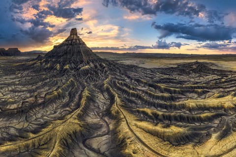 Spectacular aerial view of Factory Butte at sunset with vivid sky colors and intricate erosional