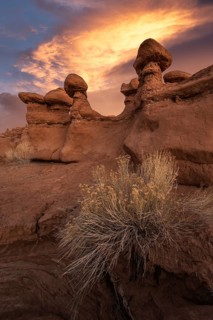 Stunning sandstone formations at Goblin Valley State Park, Utah, bask under a dramatic sunset. The