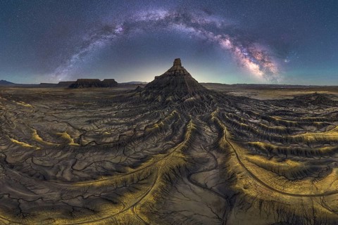 Stunning night scape of Utah sandstone desert under the Milky Way. The starry sky arches over