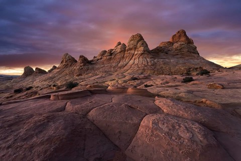 A majestic sunset casts warm colors over the unique sandstone formations at Coyote Buttes, located