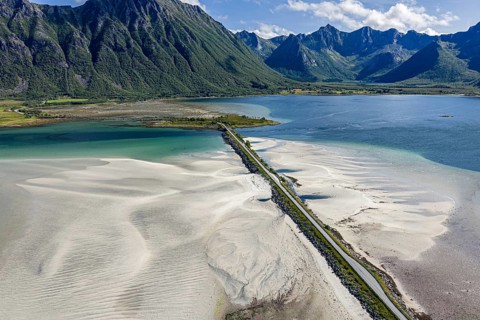 Aerial view of a bridge over turquoise sea at a sandy beach, fjord Grunnforfjorden, Lofoten