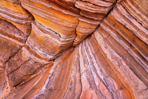 Close-up image of layered red rock formations showing vivid stripes and textures. Perfect for