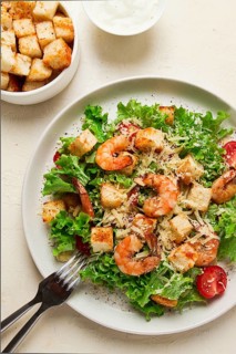Caesar salad, with shrimp, on a white background, homemade, no people