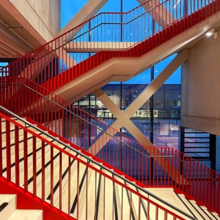 Staircase with signal red color scheme in seminar building H of Bochum University in the evening