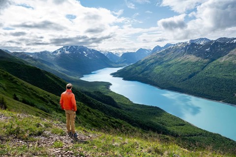 Mountaineer enjoys views of blue lake and mountains on Twin Peaks Trail, Eklutna Lake, Chugach