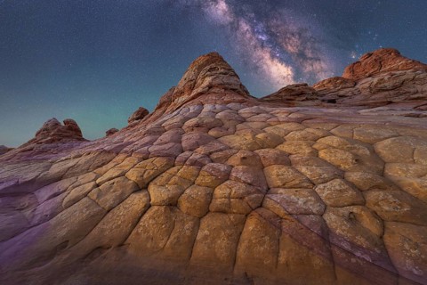 A breathtaking view of the Milky Way illuminating a unique, textured rock formation in Coyote