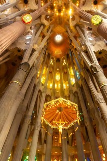 Sunlight illuminating the canopy and crucifix hanging from the ceiling of the sagrada familia in