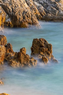 Crystal clear and turquoise water on the beach of Ustrine Bay on a sunny day at sunset on the