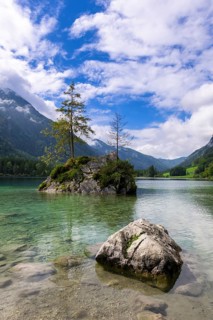 Hintersee near Ramsau with clear green water, surrounded by forests and mountains under a cloudy
