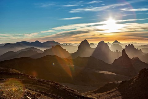 Sunbeams break through the haze over a mountain landscape at sunset, The landscape of the Ahaggar