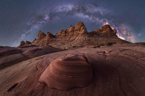 An awe inspiring view of the Milky Way galaxy illuminating the night sky above a rugged desert
