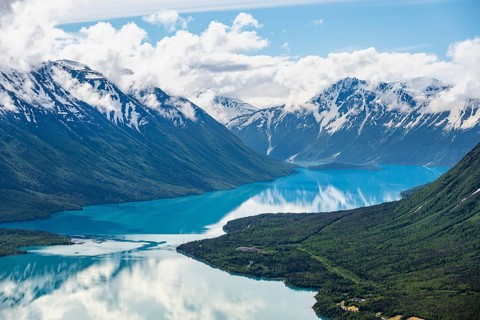 View of snowy mountains in spring and turquoise Kenai Lake with reflection, Slaughter Ridge Trail,