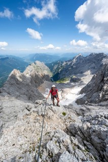Mountaineer with helmet in a secured via ferrata, Zugspitze via ferrata, ascent to the Zugspitze,