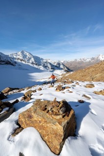 Mountaineer on a hiking trail with snow, descent from Ramoljoch at Spiegelferner, autumnal mountain
